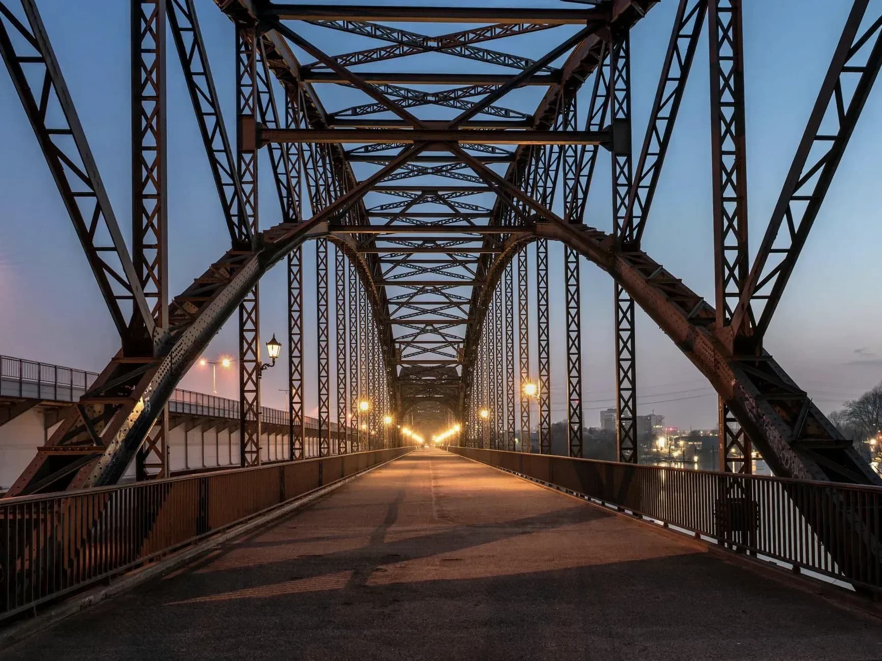 A steel arch bridge at dusk